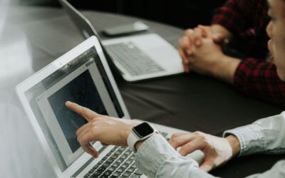 Effective delegation: One individual points to a computer screen as another observes